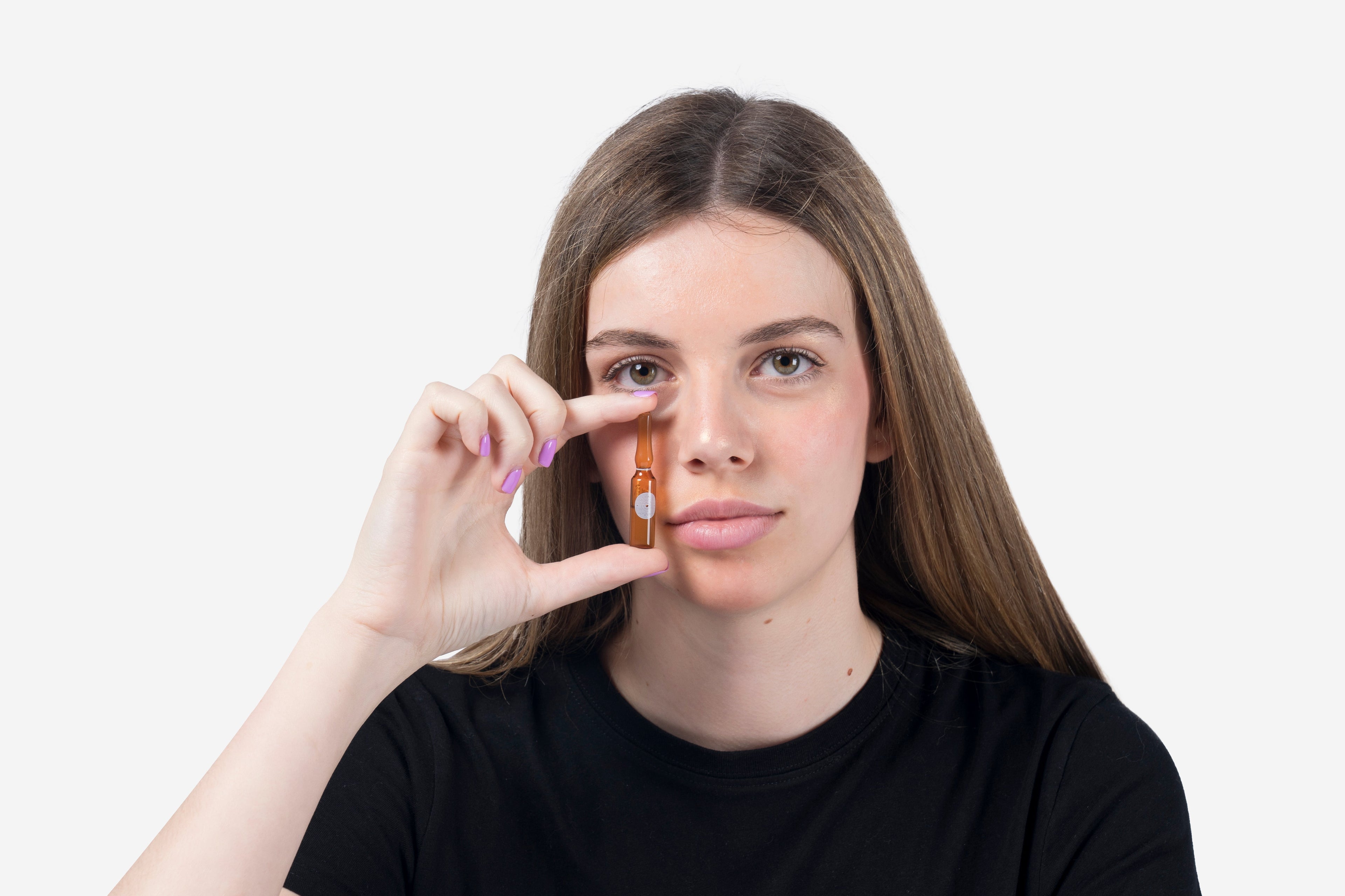 Young model holding a facial ampoule