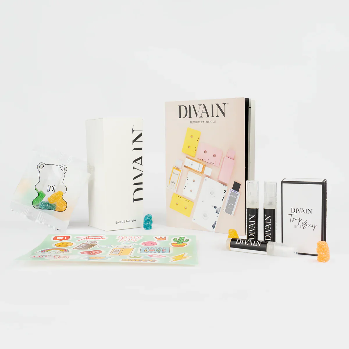 Opened divain package containing divain-120 perfume, stickers, and gummy candies
