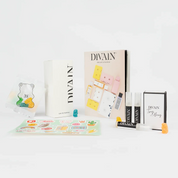 Opened divain package containing divain-957 perfume, stickers, and gummy candies
