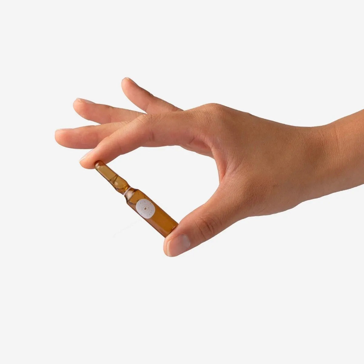 Divain Care cosmetic ampoule held between fingers.