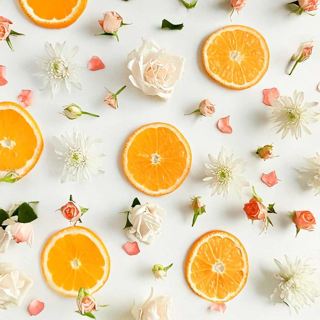 Citrus and floral olfactory notes with orange slices, white roses and pink flowers