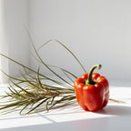 Red pepper and vetiver representing the olfactory notes of the perfume.
