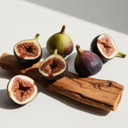 Figs and wood representing the olfactory notes of the perfume.