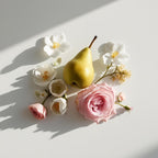 Pear and rose representing the olfactory notes of the perfume.
