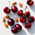 Cherries and almonds representing the olfactory notes of the perfume.