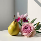Pear and rose representing the olfactory notes of the perfume.