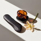 Amber, saffron and black wood representing the olfactory notes of the perfume.