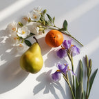 Pear, orange and orange blossom representing the olfactory notes of the perfume.