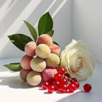 Lychee, rose and red currant representing the olfactory notes of the perfume.
