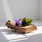 Violet, blackberry and wood representing the olfactory notes of the perfume.