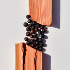 Cedar and black pepper representing the olfactory notes of the perfume.