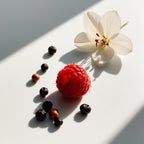 Magnolia, raspberry and pepper representing the olfactory notes of the perfume.