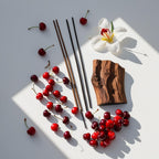 Wood, incense and red fruits representing the olfactory notes of the perfume.