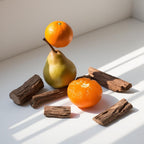 Mandarin, pear and pieces of wood representing the olfactory notes of the perfume.