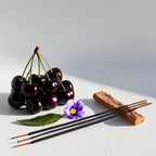 Black cherry, violet, incense and wood representing the olfactory notes of the perfume.